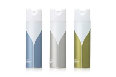 Three slim aerosol cans in blue, grey and olive, each with a white tapering V shape