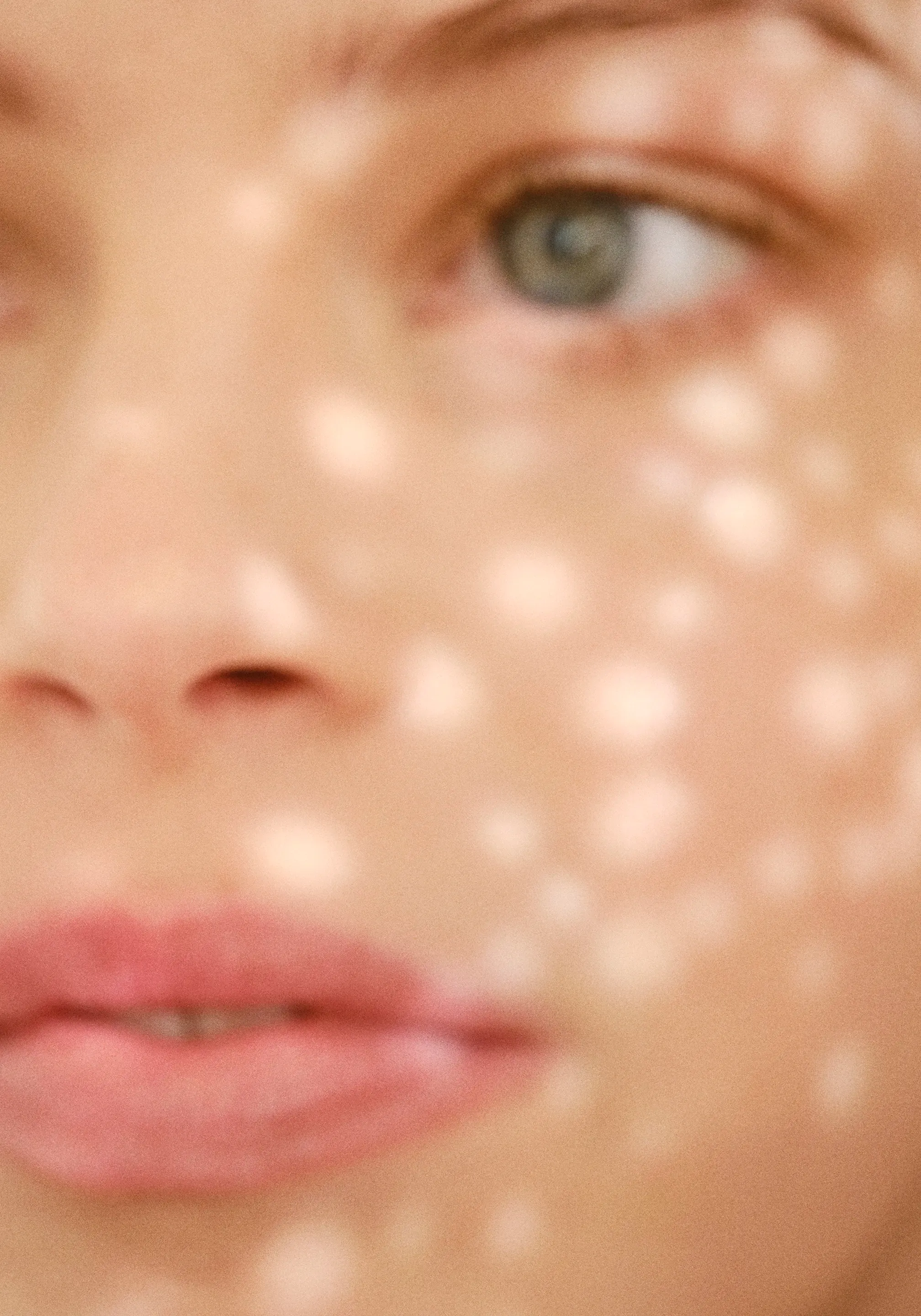 Olink campaign close-up: a soft-focus face with green eyes, speckled with light