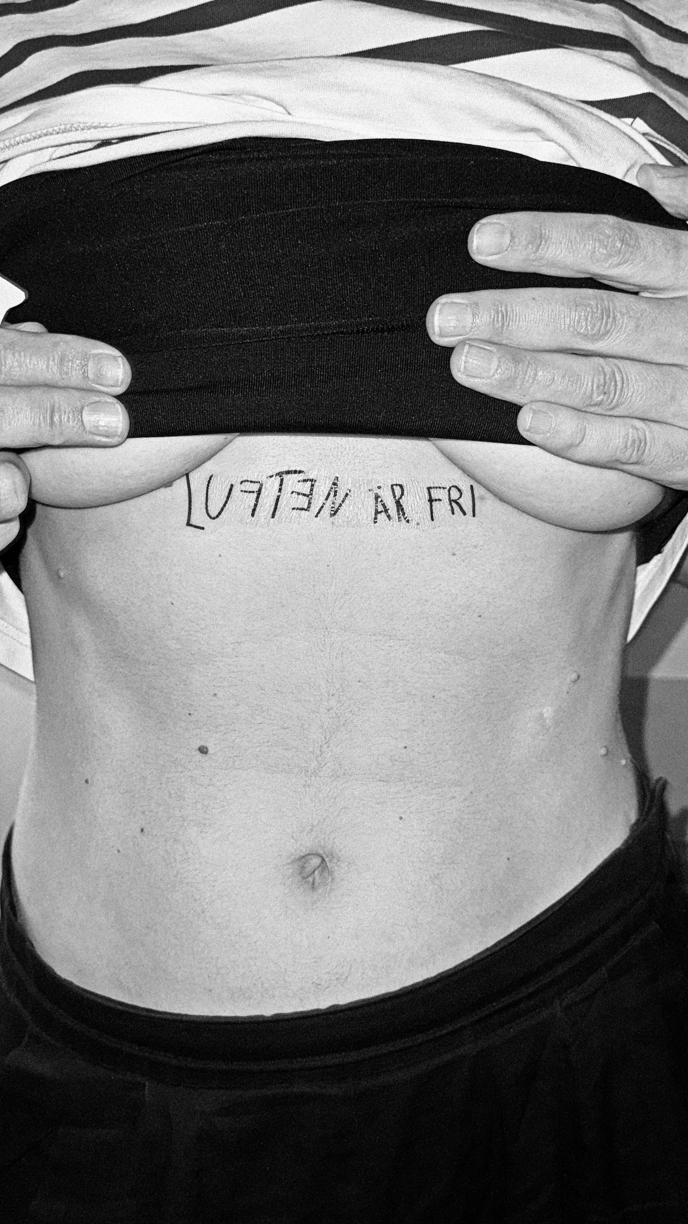 “Luften är fri” written across a ribcage below a lifted top