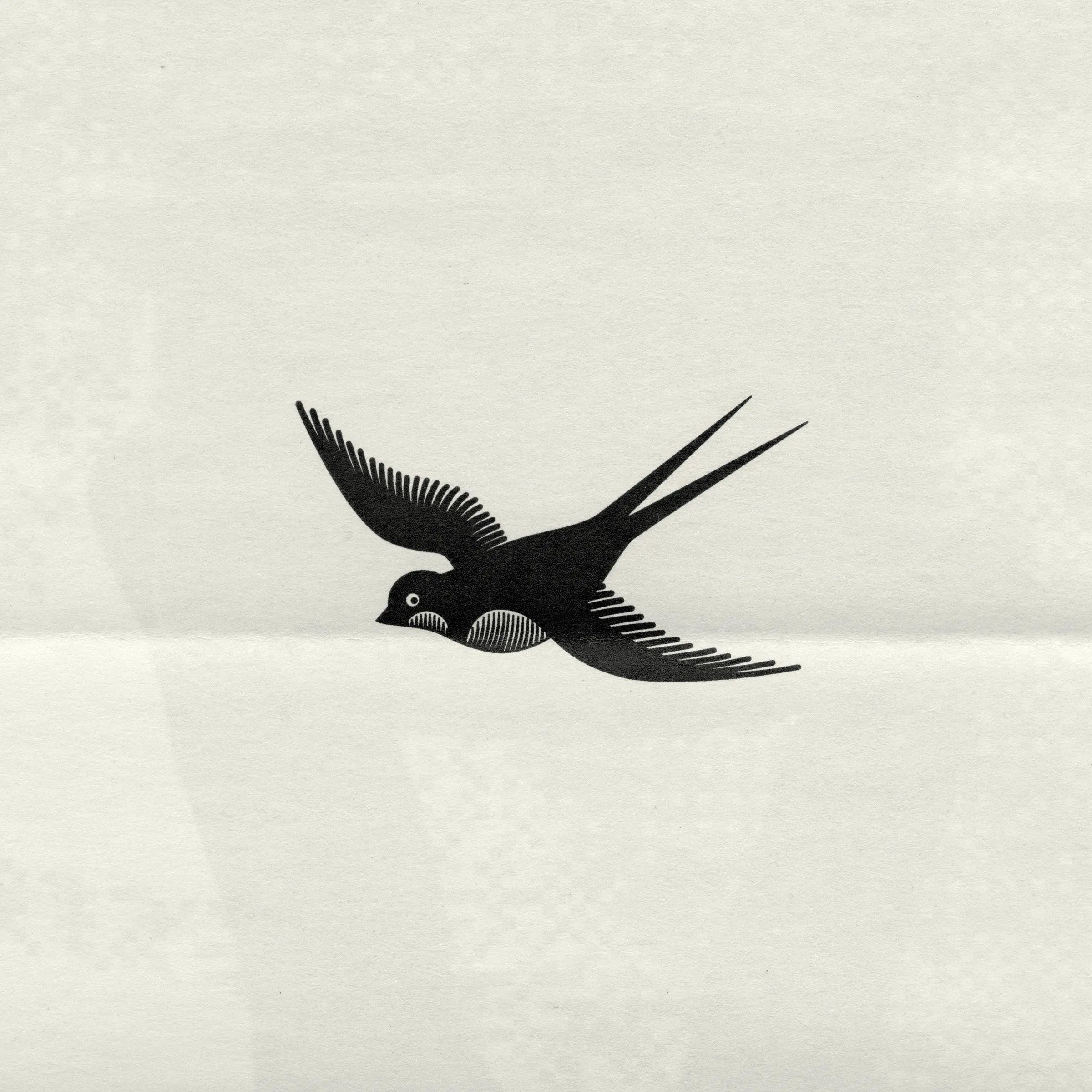 An engraved black swallow in flight, printed on folded off-white paper